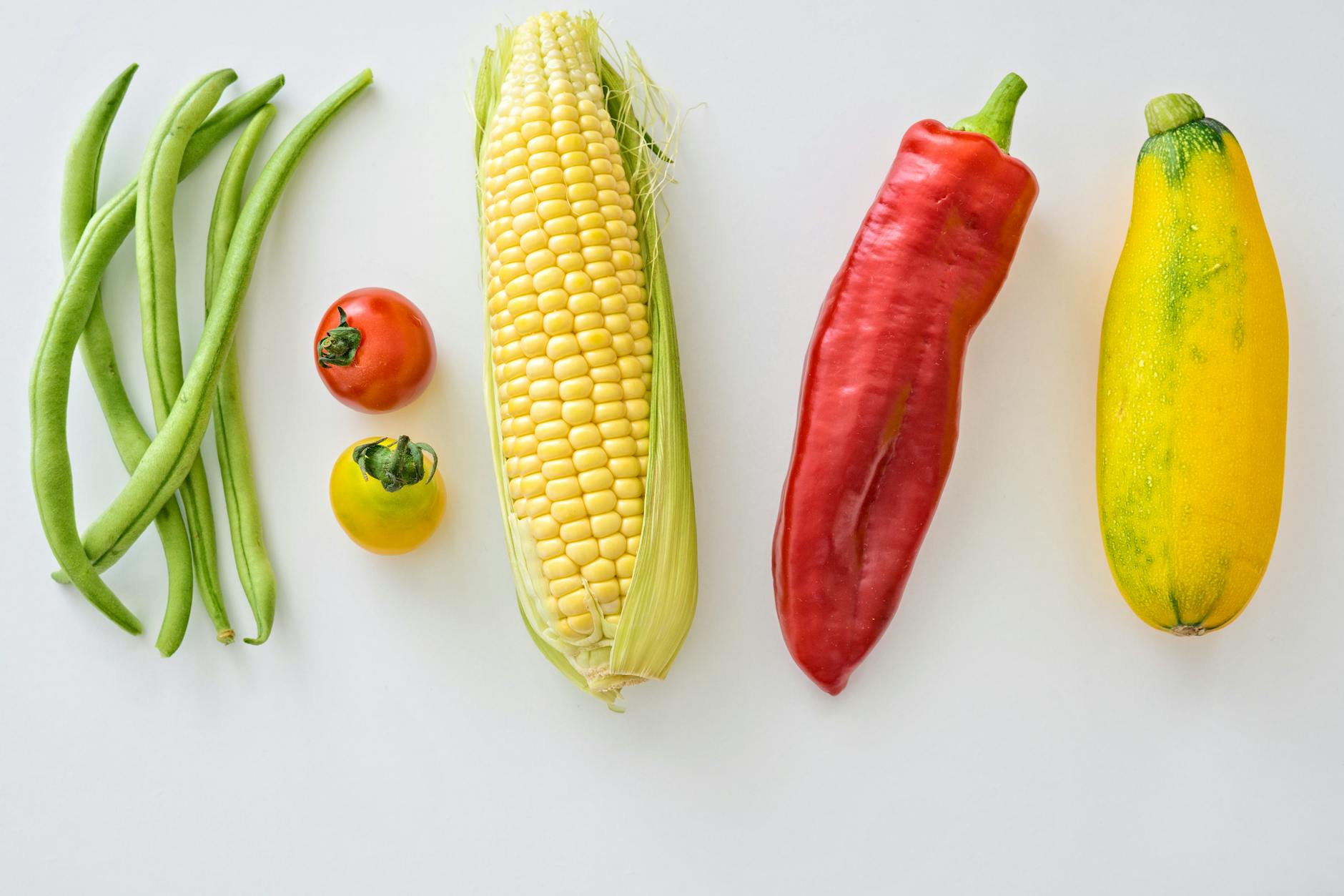 five assorted vegetables on white surface