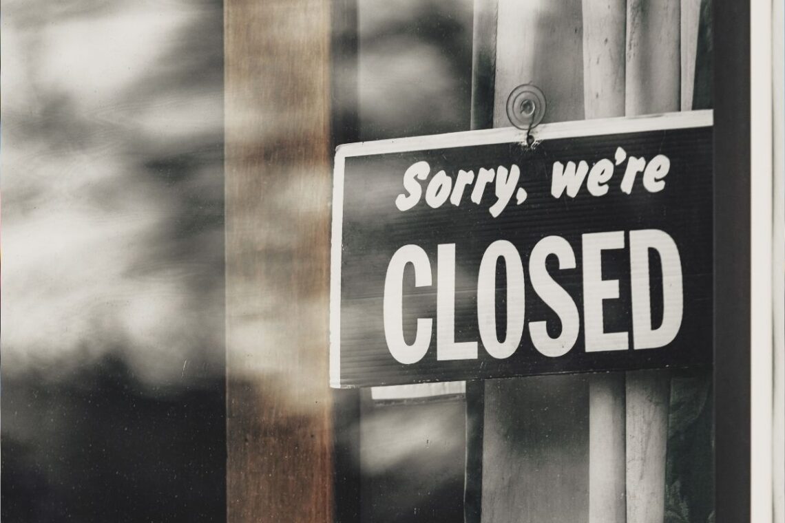 A sign in a restaurant window reads 'sorry, we're closed'