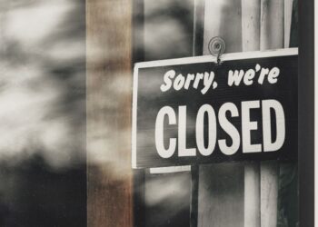 A sign in a restaurant window reads 'sorry, we're closed'